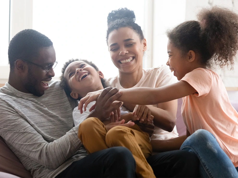 Happy family playing on a couch