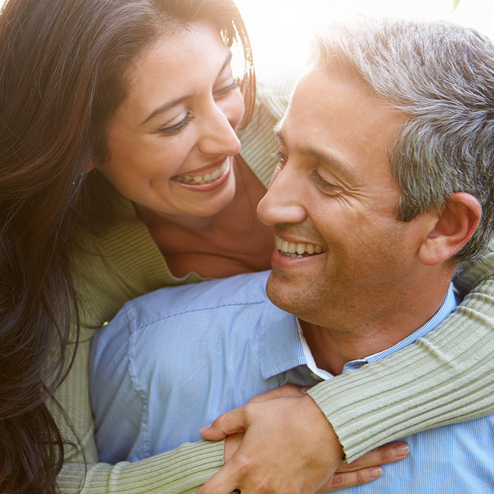 happy middle-aged couple smiling brightly outdoors
